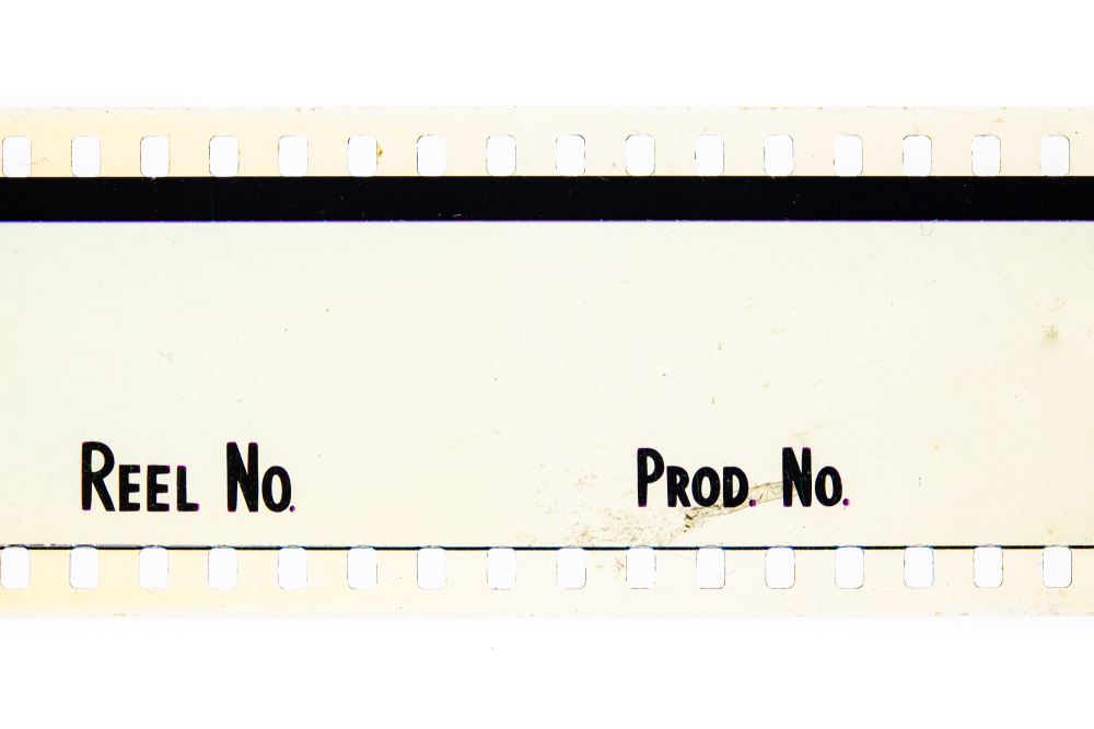 Vintage film reels and a clapperboard resting on aged paper manuscripts