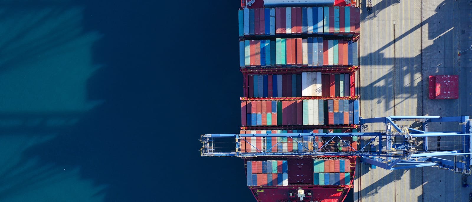Cargo containers stacked at an international shipping port at dusk