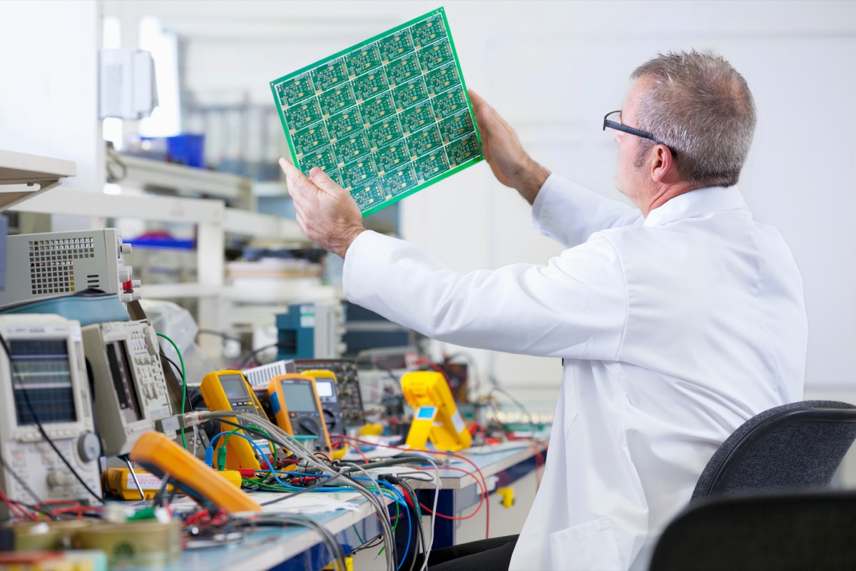An engineer testing telecommunications circuit boards with electronic instruments