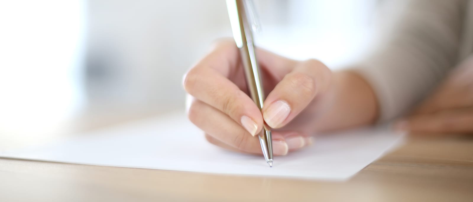 A confidentiality agreement on a desk beside a fountain pen and reading glasses