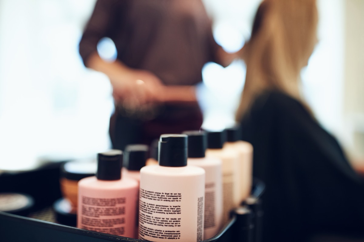 Row of hair-care and shampoo bottles on a salon shelf
