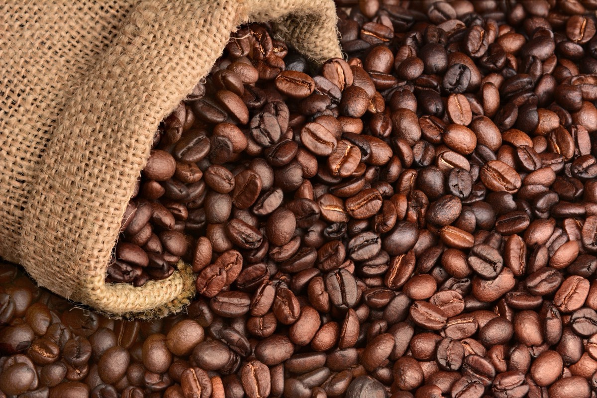 Dark roasted coffee beans spilling from a bag