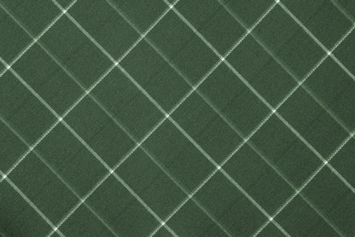 A close-up of a green-gold colored fabric pad against a neutral background