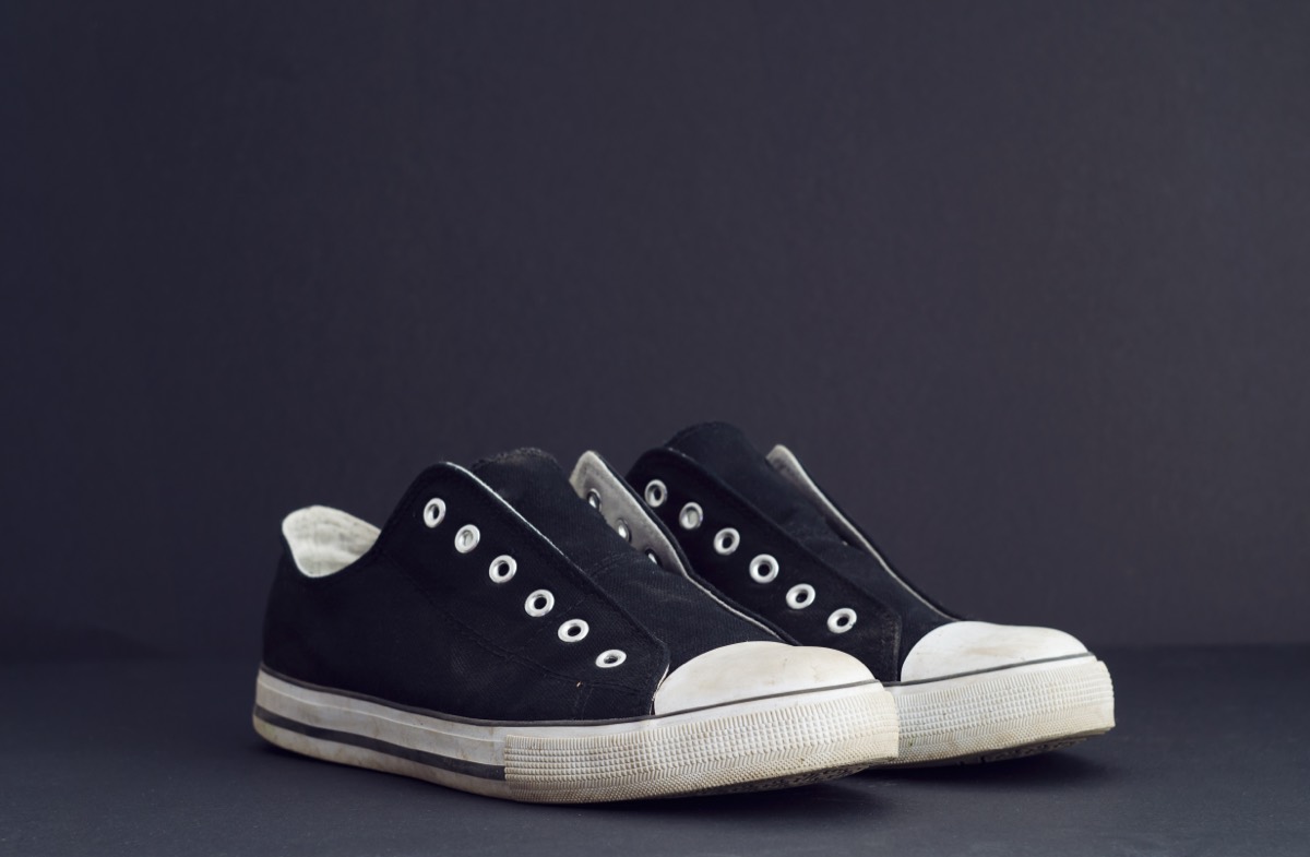Pairs of black and white canvas skate sneakers lined up on a store display shelf